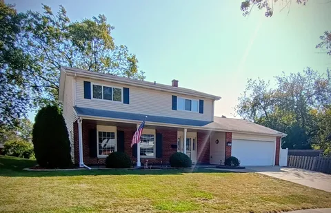 a view of a brick house with large windows and a large tree