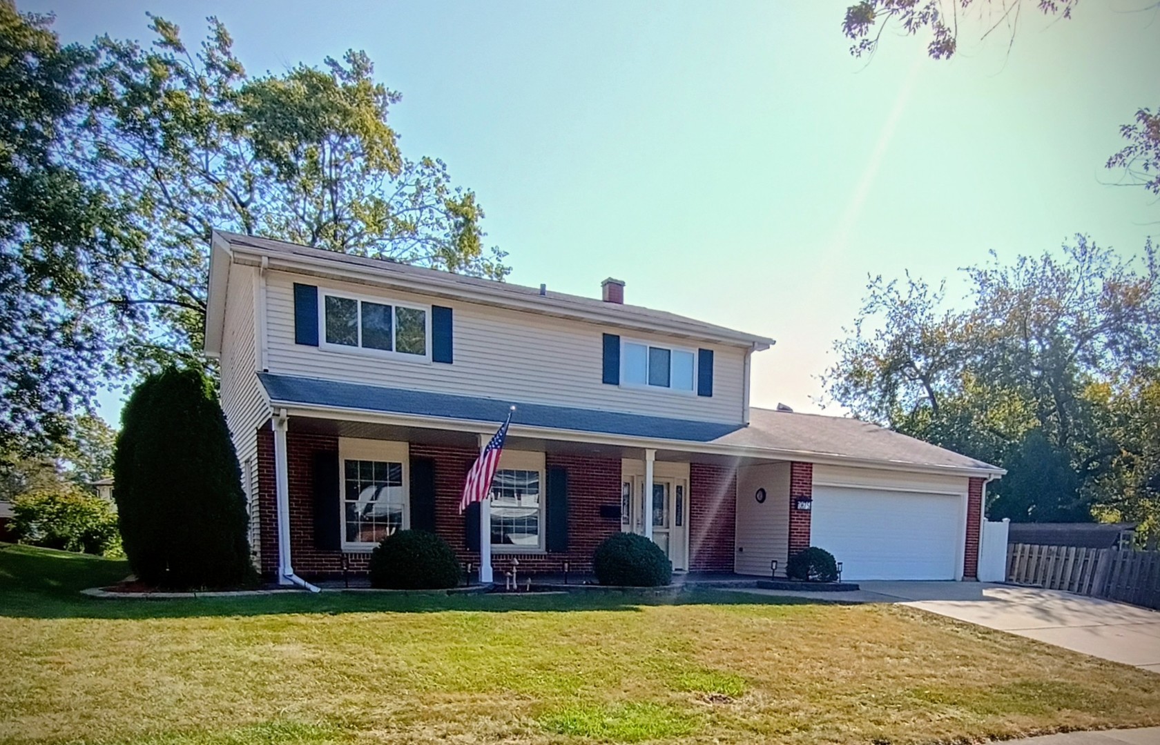 a view of a brick house with large windows and a large tree