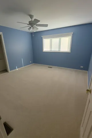 en empty room with windows and fan