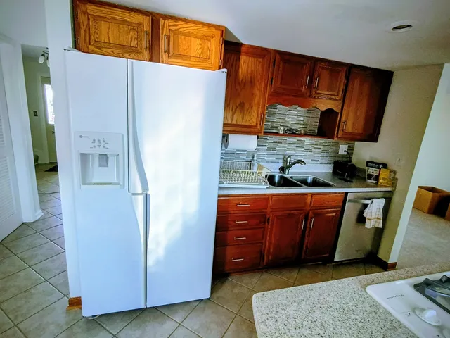 a kitchen with stainless steel appliances granite countertop a refrigerator and a sink