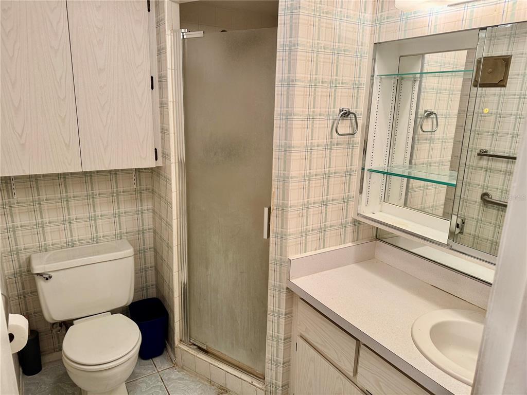 12300 Vonn Road, Unit 5304 Largo, FL 33774 - Photo 19 of 21 a bathroom with a granite countertop sink a toilet and shower