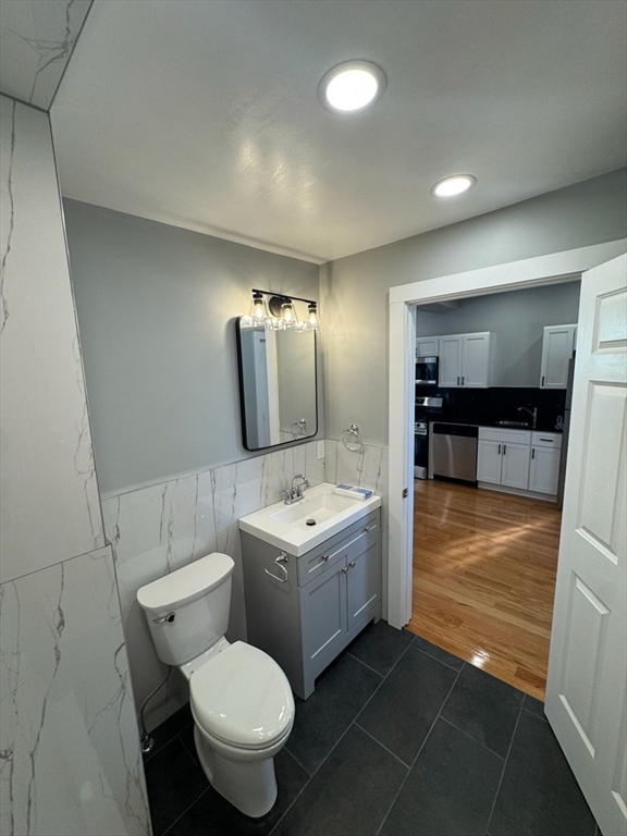 193 Winter Street, Unit 1 Saugus, MA 01906 - Photo 11 of 15 a bathroom with a sink toilet a mirror and bathtub
