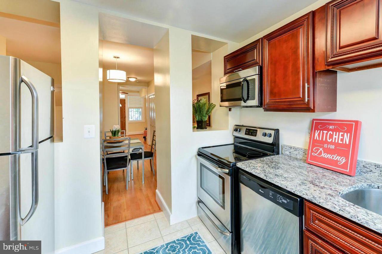 1648 L Street Northeast Washington, DC 20002 - Photo 11 of 27 a kitchen with stainless steel appliances granite countertop a refrigerator a stove top oven a sink and dishwasher