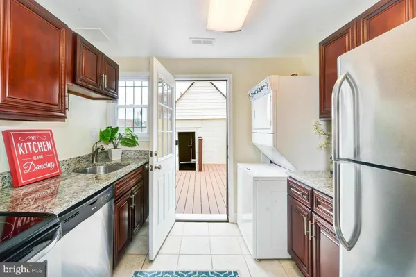 a kitchen with stainless steel appliances granite countertop a refrigerator a stove and a sink with wooden floor
