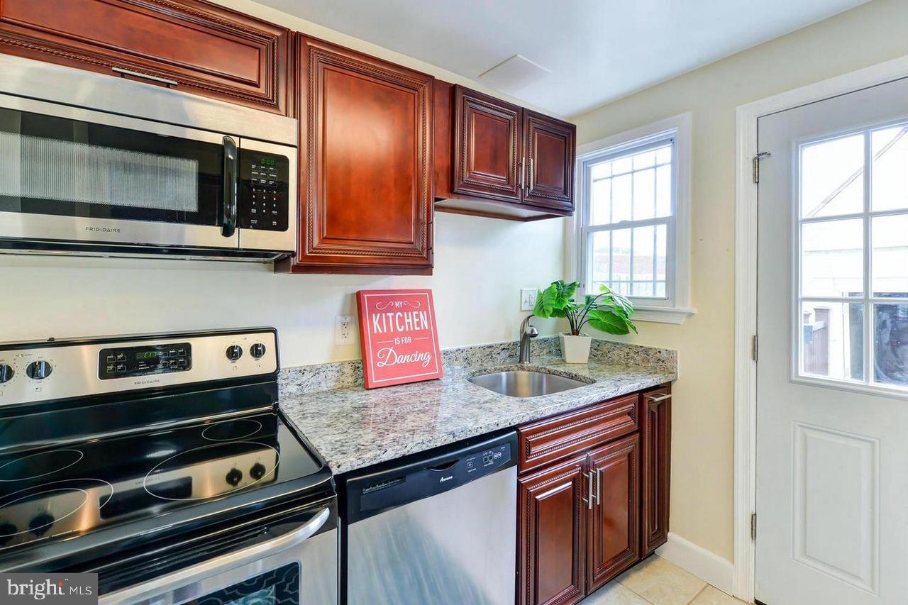 1648 L Street Northeast Washington, DC 20002 - Photo 10 of 27 a kitchen with granite countertop a stove microwave and sink