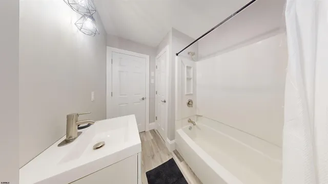 a bathroom with a tub a sink and a shower