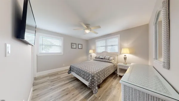 a bedroom with a bed window and a flat screen tv