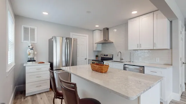 a kitchen with a refrigerator a stove a sink dishwasher with a dining table and chairs