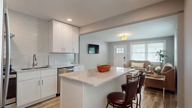 a kitchen with a dining table chairs and white cabinets