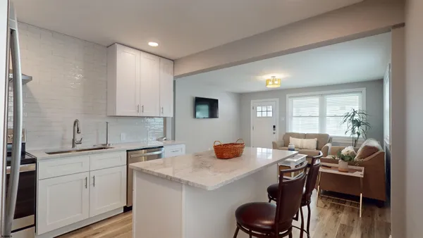a kitchen with a dining table chairs and white cabinets