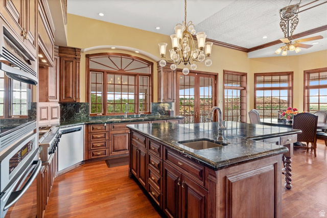 5615 East Eight Mile Gap Road Kanab, UT 84741 - Photo 10 of 81 Kitchen featuring dark stone counters, a spacious island, tasteful backsplash, dark wood-style floors, and stainless steel appliances