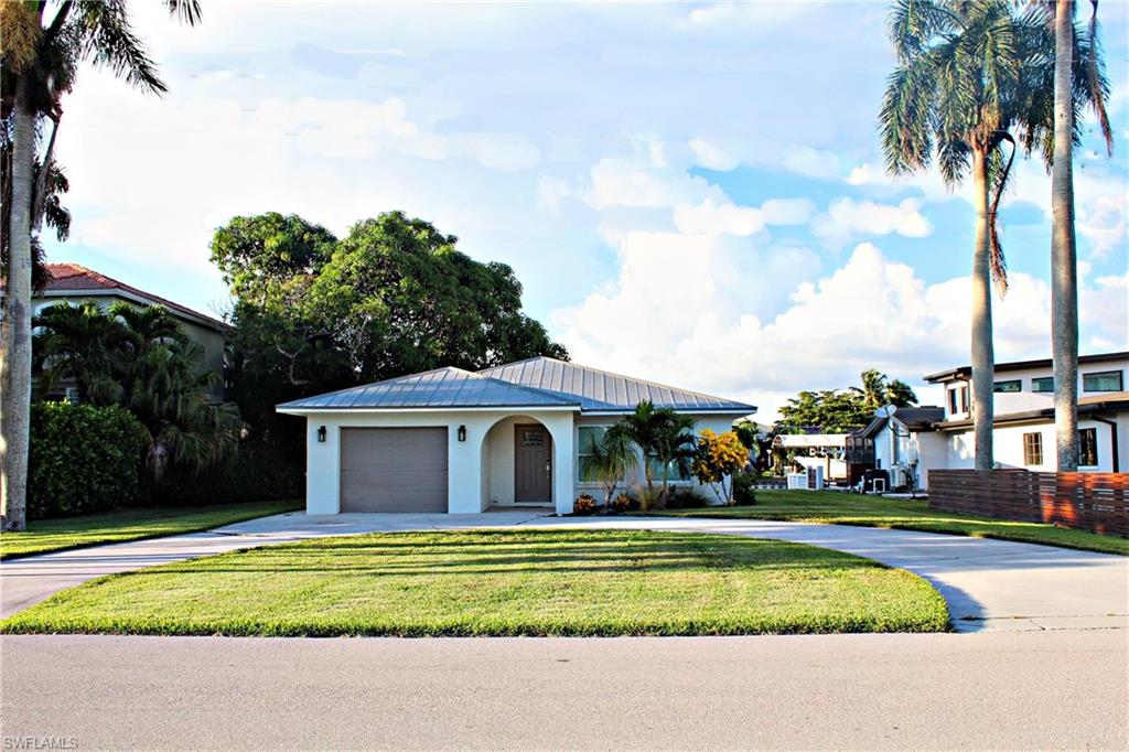 217 3rd Street Bonita Springs, FL 34134 - Photo 11 of 14 a front view of a house with a garden and pathway