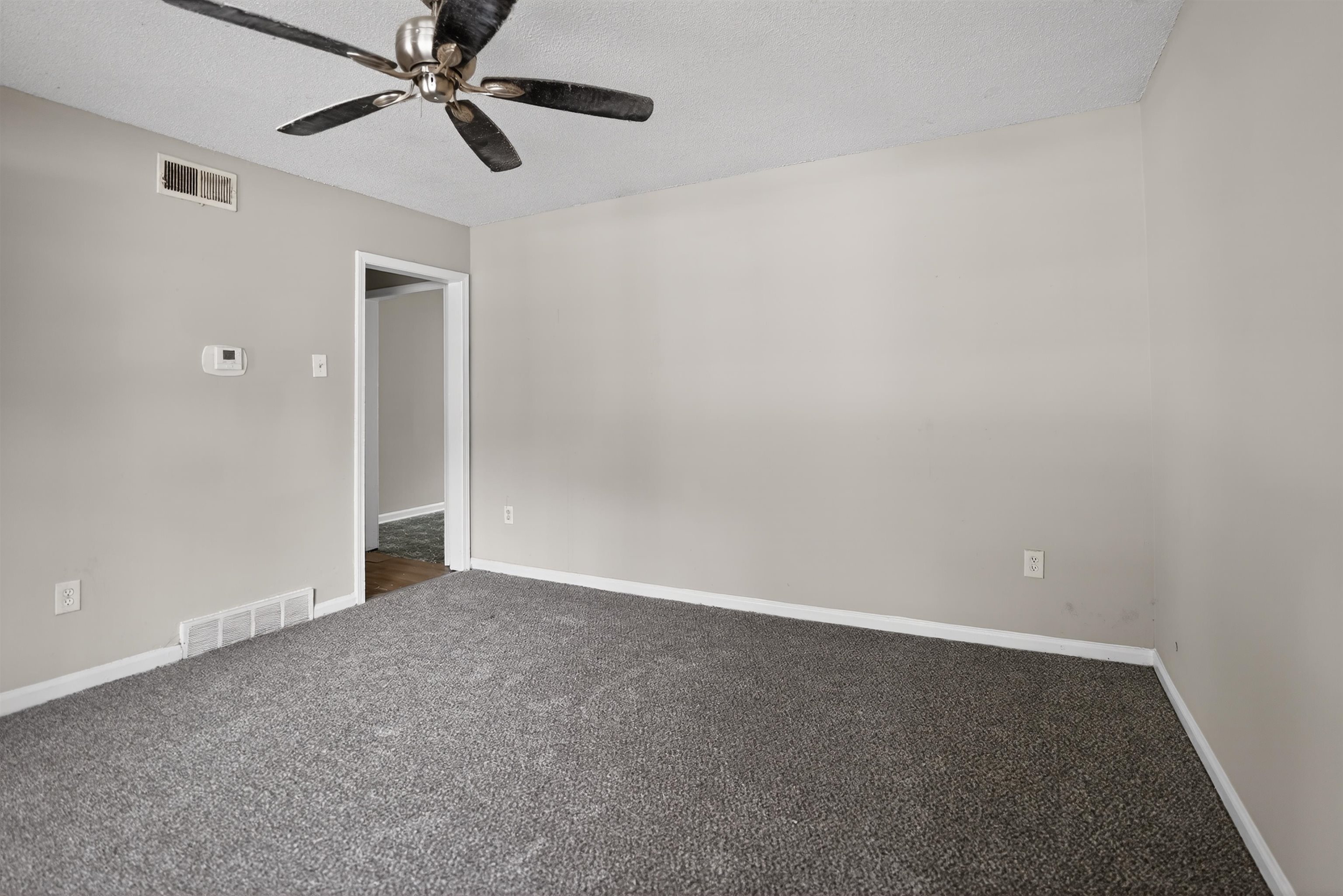 4530 Spring Valley Drive Memphis, TN 38128 - Photo 7 of 15 Interior room featuring gray textured carpeting, light neutral wall paint, and white baseboards