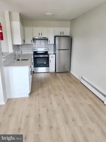 a kitchen with a refrigerator a stove top oven and a sink