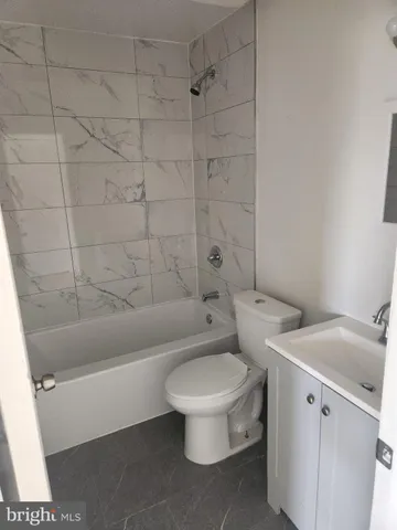 a white toilet sitting next to a bath tub