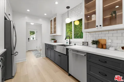 a kitchen with stainless steel appliances granite countertop a sink a stove and a refrigerator