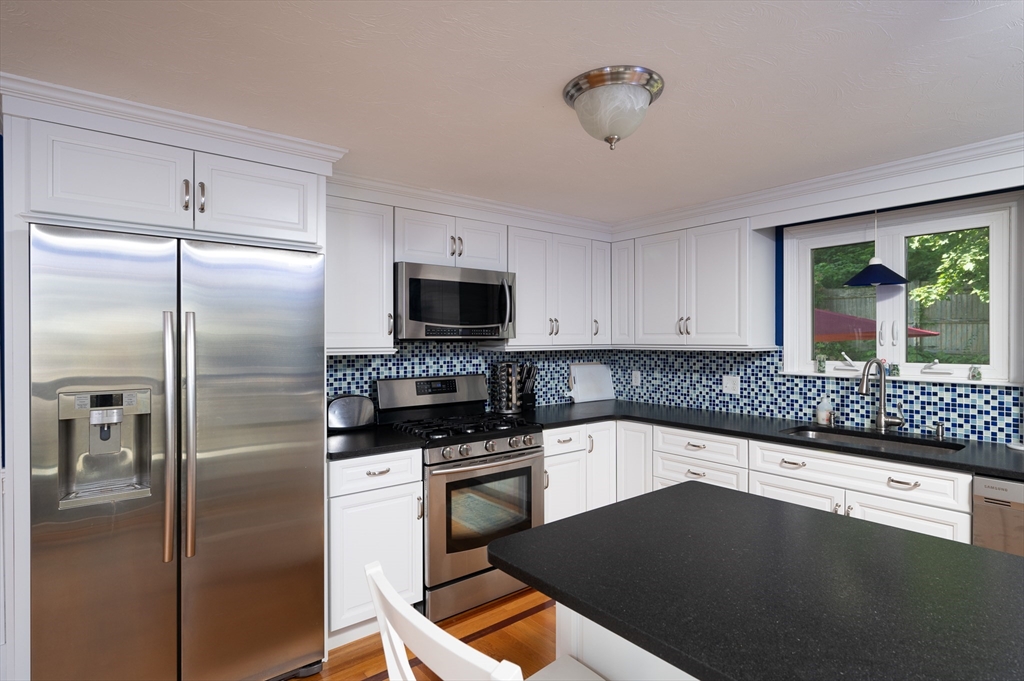 29 Wituwamat Road Weymouth, MA 02191 - Photo 13 of 42 a kitchen with a refrigerator a stove a microwave and cabinets