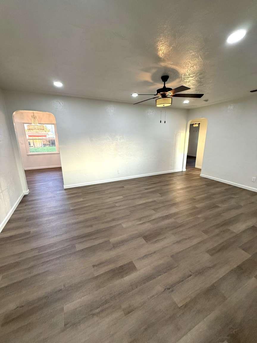 520 Colfax Avenue Modesto, CA 95354 - Photo 3 of 18 an empty room with wooden floor and windows