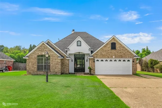 a front view of a house with a garden and garage