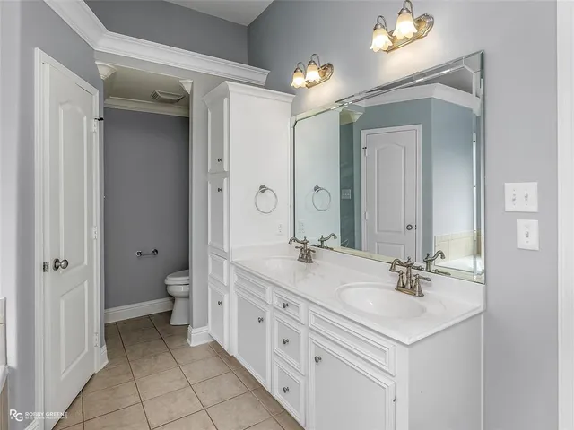 a spacious bathroom with a double vanity sink mirror and toilet