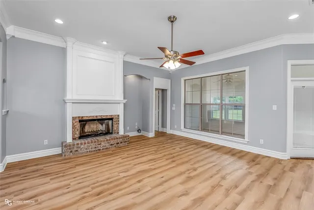 a view of an empty room with a fireplace and a window