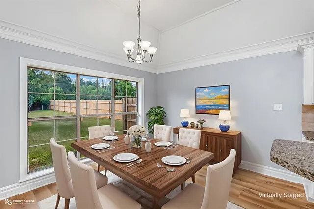 a view of a dining room with furniture wooden floor and a chandelier