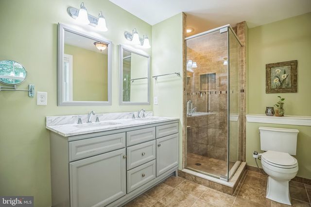 a bathroom with a shower sink vanity mirror and toilet