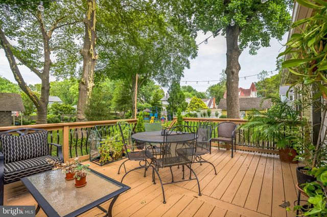a balcony with wooden floor table and chairs