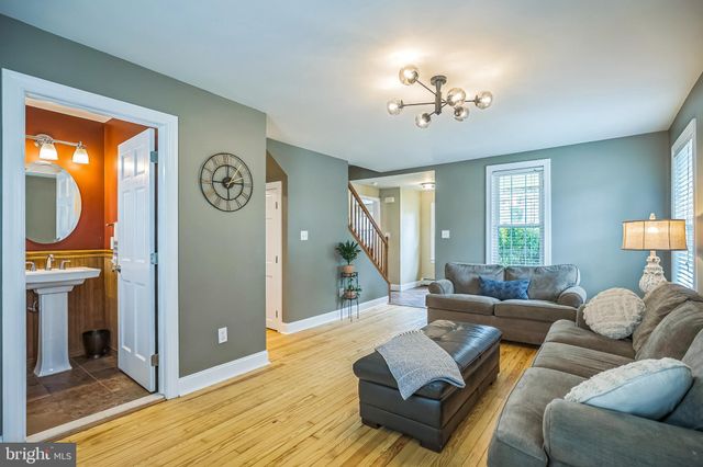 a living room with furniture a chandelier and a window