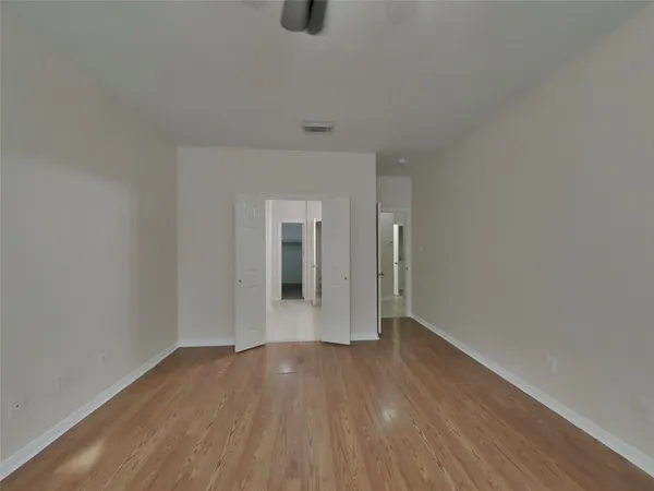 a view of an empty room with wooden floor