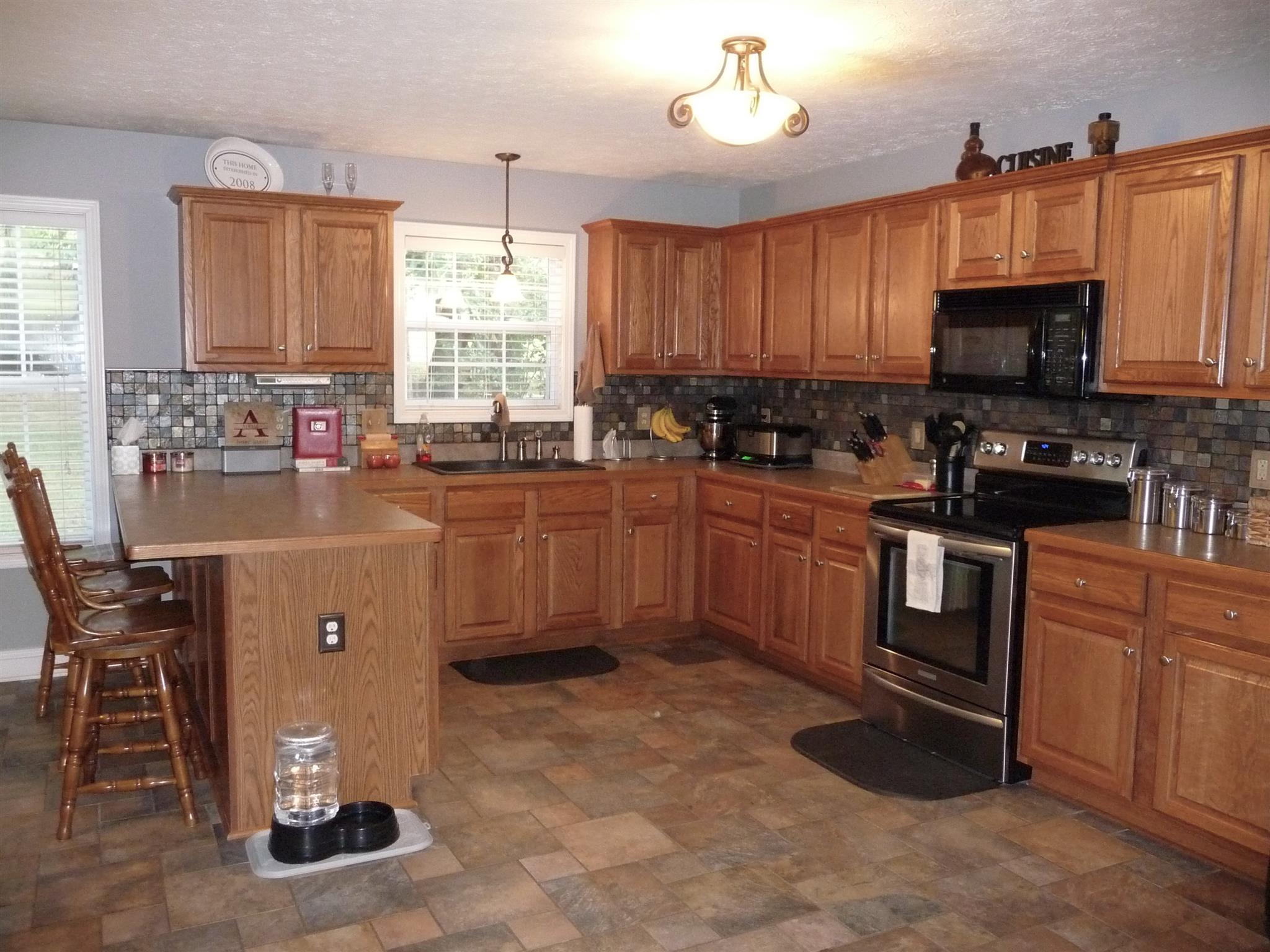 198 Wilkinson Road Cottontown, TN 37048 - Photo 4 of 23 a kitchen with stainless steel appliances granite countertop a sink a stove a microwave a refrigerator cabinets and dining table