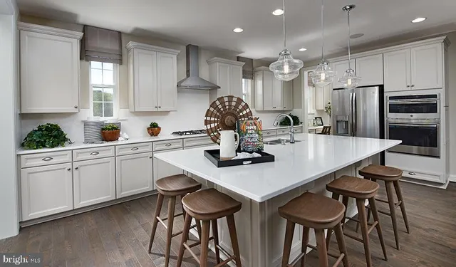 a kitchen with granite countertop a table chairs stove and cabinets