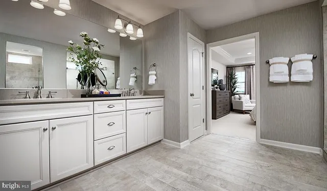 a spacious en suite bathroom with a granite countertop sink a mirror and a shower