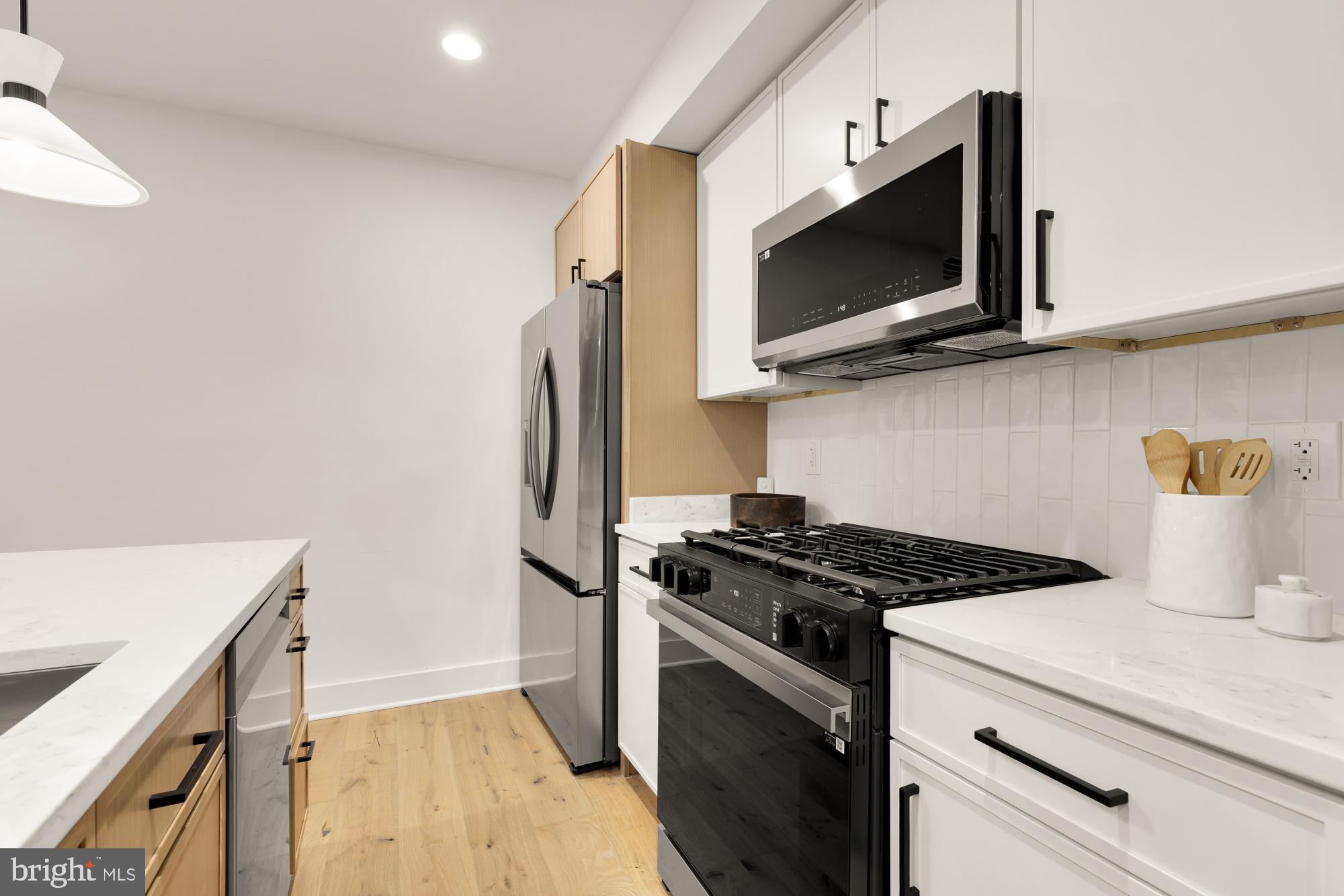 1325 Orren Street Northeast, Unit D Washington, DC 20002 - Photo 14 of 44 a kitchen with a microwave and a stove