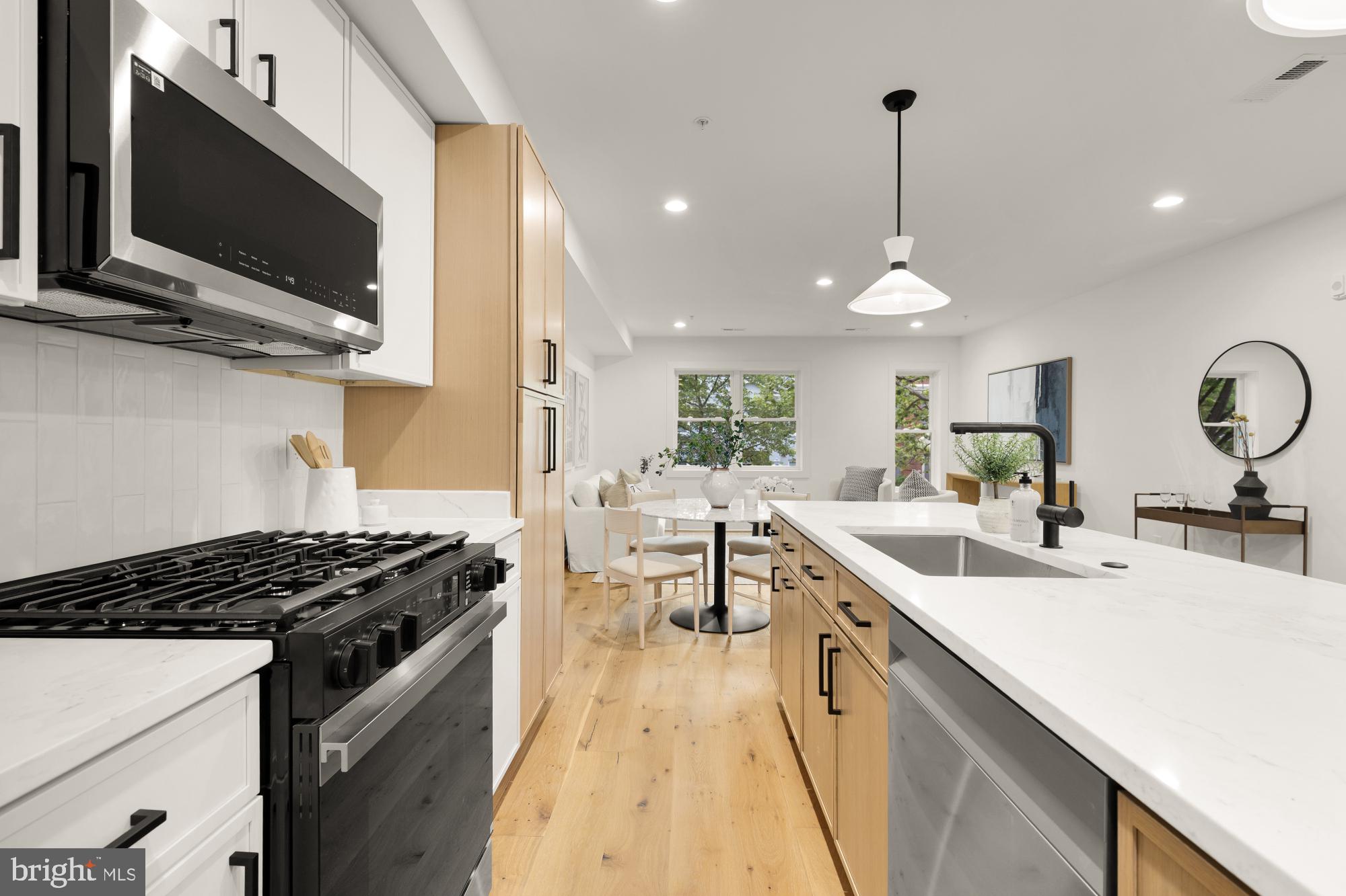 1325 Orren Street Northeast, Unit D Washington, DC 20002 - Photo 16 of 44 a kitchen with a sink stove and microwave