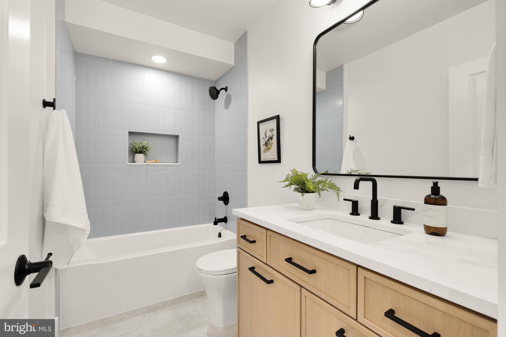 1325 Orren Street Northeast, Unit D Washington, DC 20002 - Photo 18 of 44 a bathroom with a granite countertop sink a toilet and a bathtub