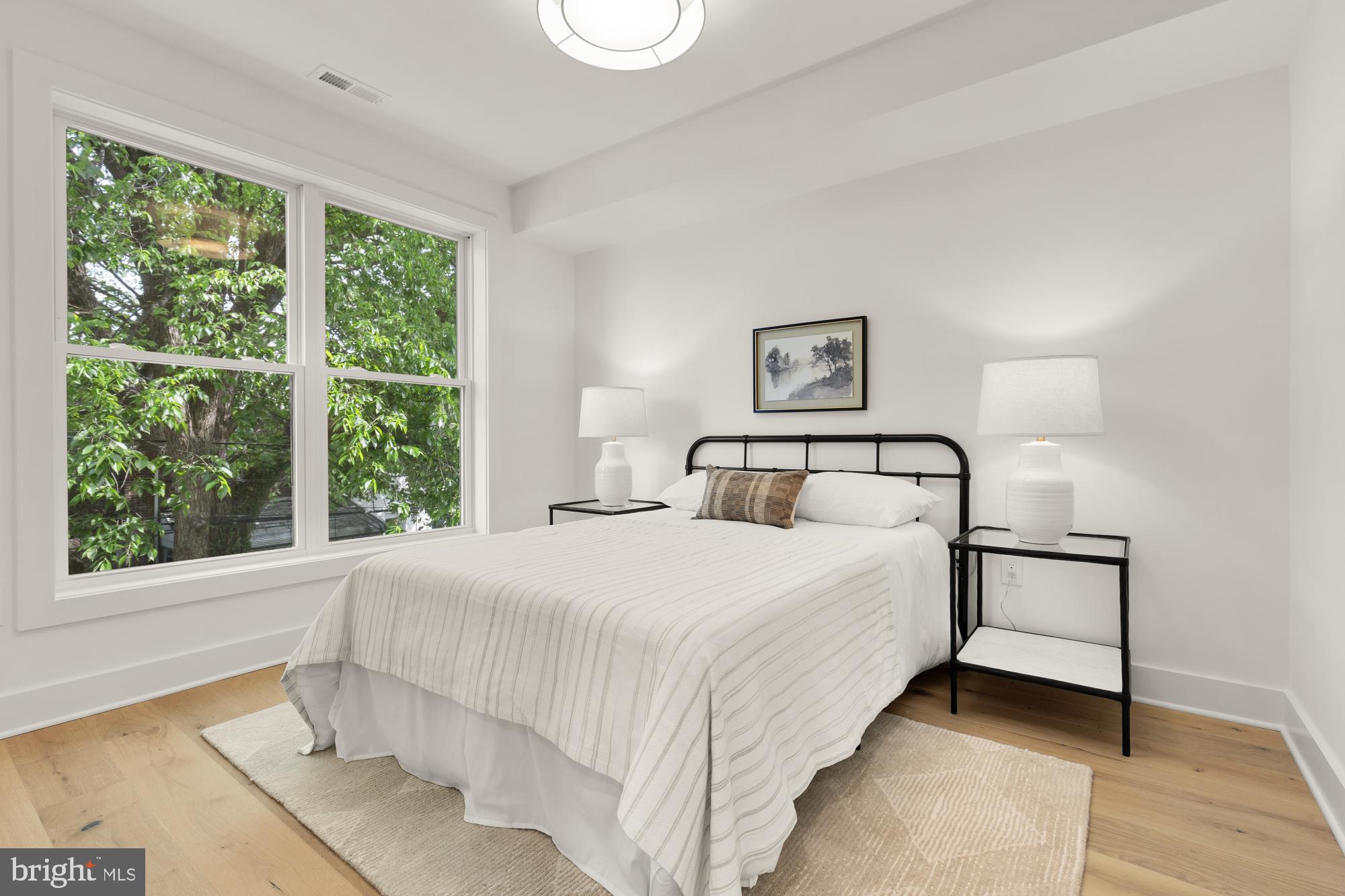 1325 Orren Street Northeast, Unit D Washington, DC 20002 - Photo 30 of 44 a bedroom with a large bed and a large window