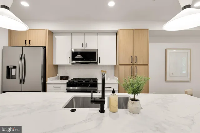 a kitchen with a refrigerator a stove a microwave a sink and cabinets