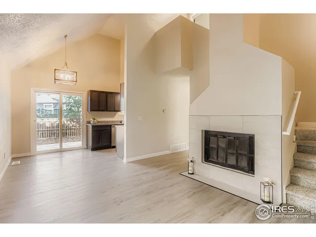 a view of empty room with wooden floor and fireplace