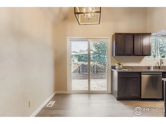 a kitchen with a sink wooden cabinets and a granite counter top