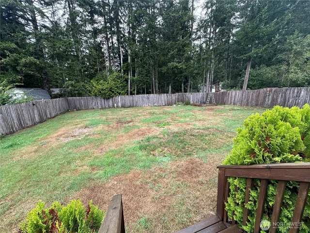 a view of a backyard with a small cabin and wooden fence