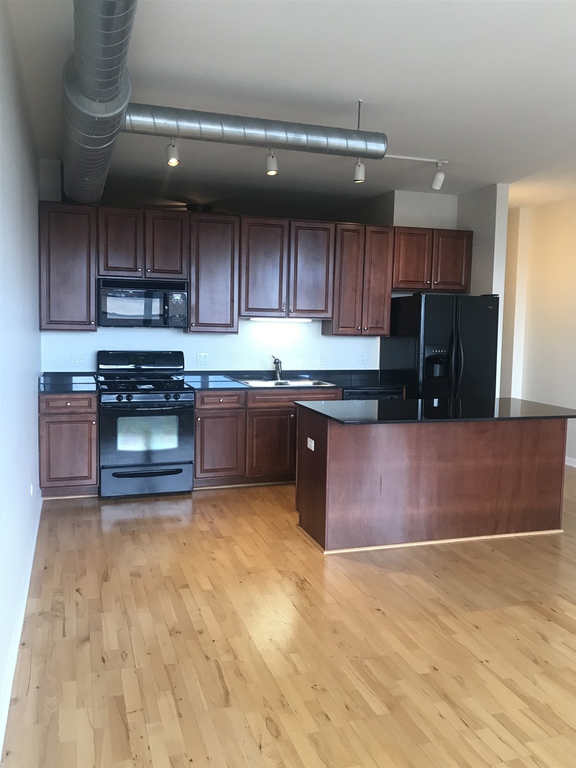 1200 West Monroe Street, Unit 618 Chicago, IL 60607 - Photo 4 of 10 a kitchen with wooden cabinets