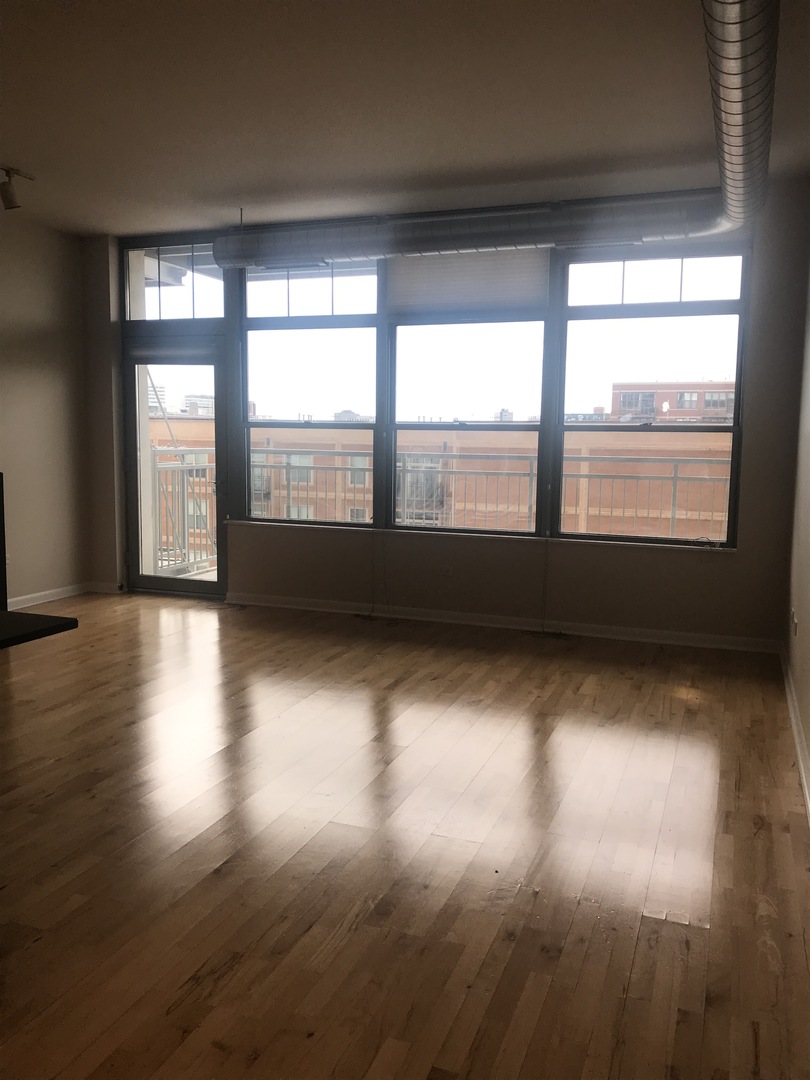 1200 West Monroe Street, Unit 618 Chicago, IL 60607 - Photo 5 of 10 an empty room with wooden floor and windows
