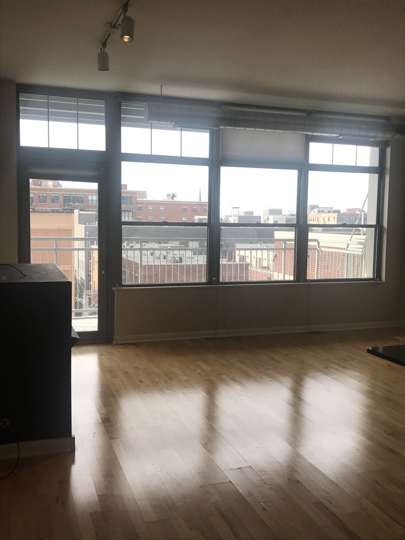 1200 West Monroe Street, Unit 618 Chicago, IL 60607 - Photo 6 of 10 a view of an empty room with wooden floor and a window