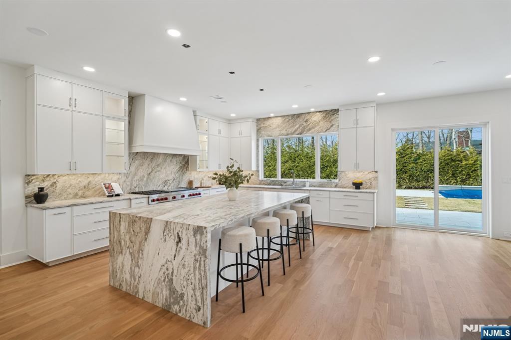 50 Roberts Road Englewood Cliffs, NJ 07632 - Photo 14 of 50 a kitchen with stainless steel appliances granite countertop a stove a sink a refrigerator and a dining table with wooden floor
