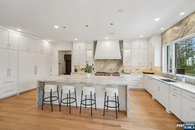 an open kitchen with white cabinets and stainless steel appliances