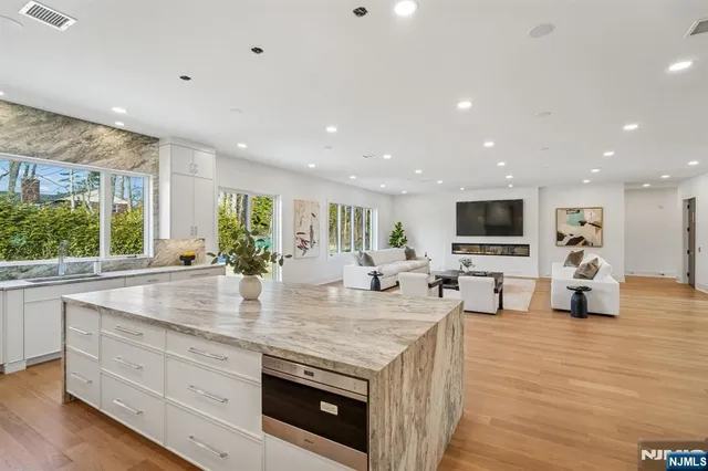 a view of kitchen with stainless steel appliances granite countertop sink stove and wooden floor