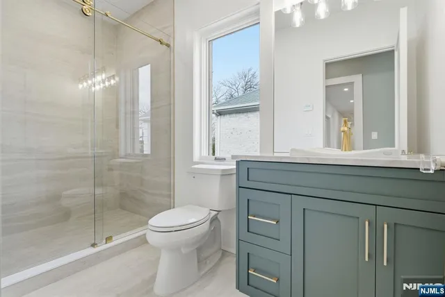 a bathroom with a toilet a sink and glass door