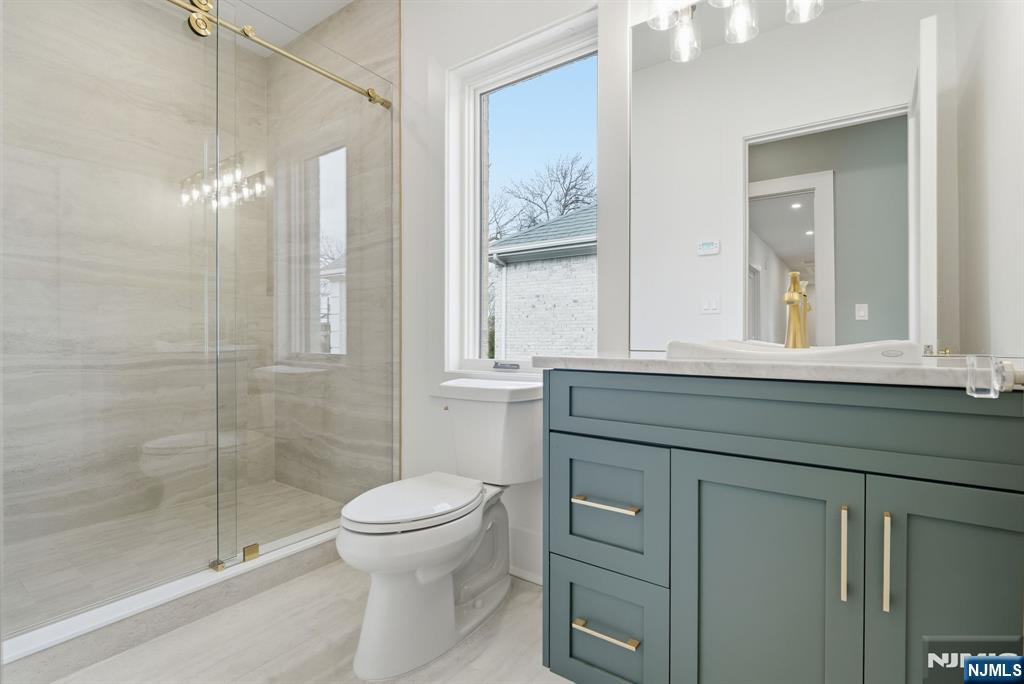 50 Roberts Road Englewood Cliffs, NJ 07632 - Photo 35 of 50 a bathroom with a toilet a sink and glass door