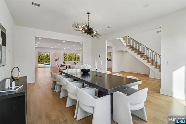 a view of a dining room with furniture a chandelier and wooden floor